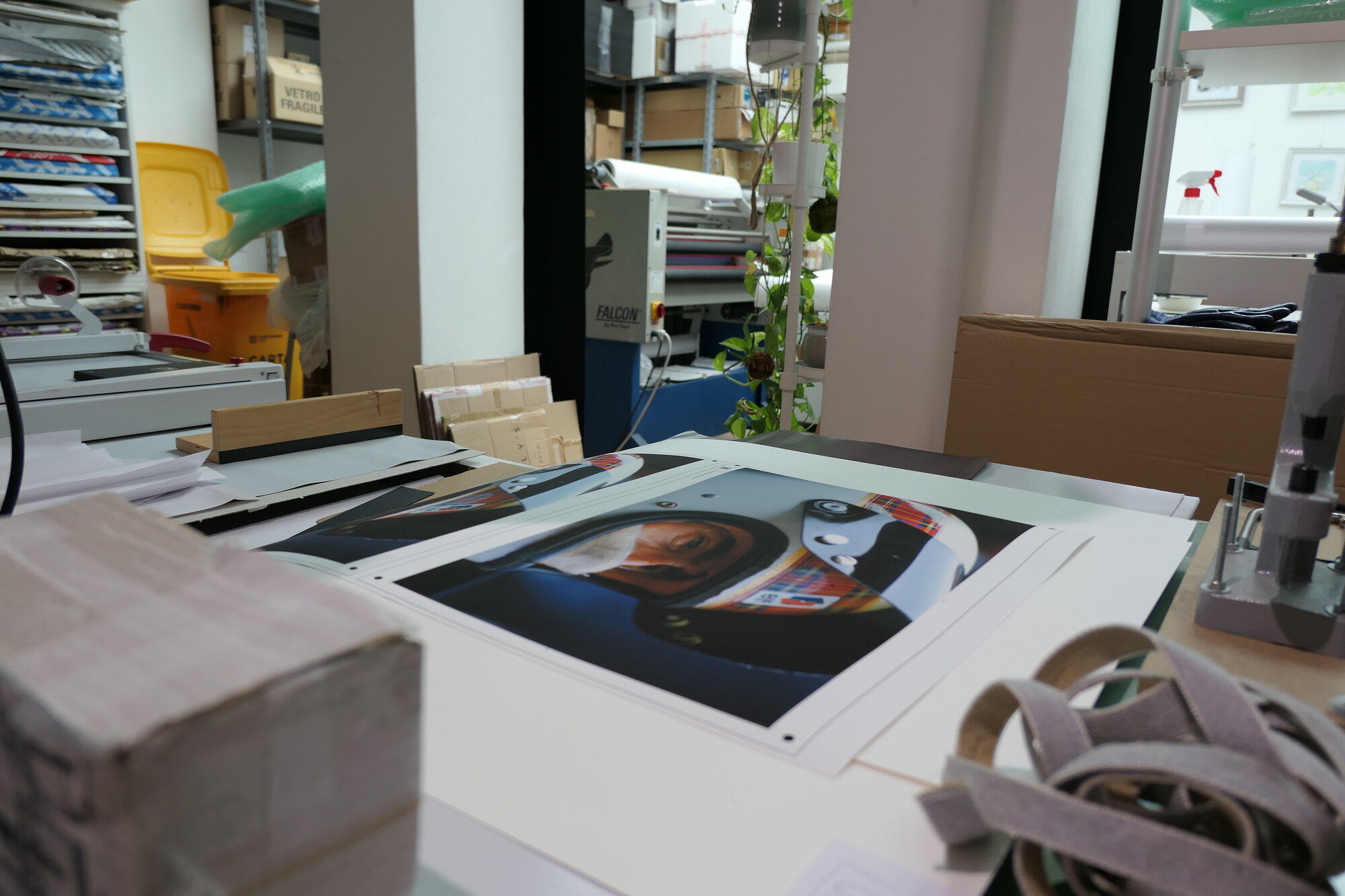 The workshop. A mounted helmet print on the bench, with the laminator behind.