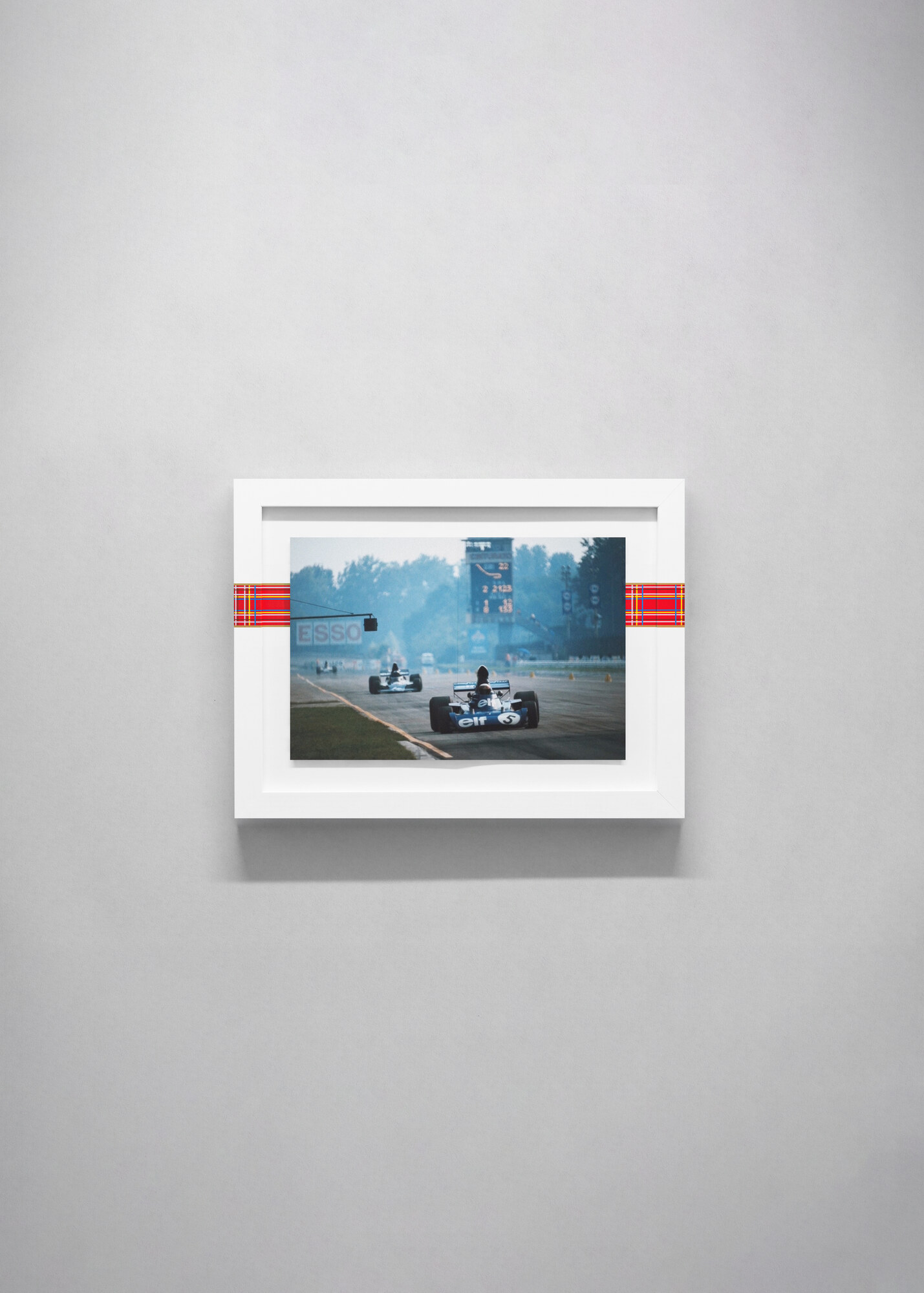 Visualisation, not a photograph. The spread with the Esso sign and timing tower, on a grey wall.